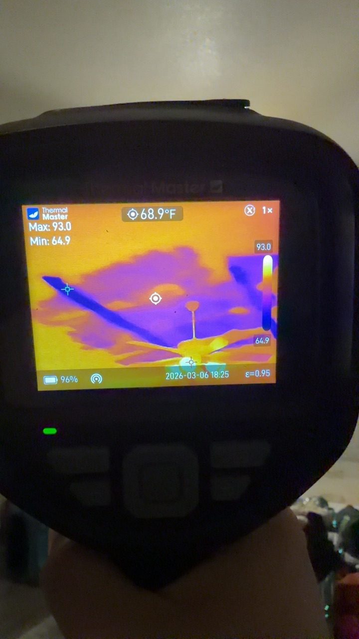 Thermal imaging camera detecting hidden moisture in a ceiling around a fan during professional inspection